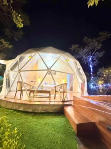 a glass dome building on a lawn at night at Glamo home kasauli in Kasauli