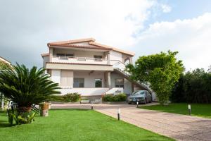a house with a car parked in front of it at Mhometredici Guest House - Camere moderne a Sestu vicino aeroporto Cagliari e Policlinico in Sestu