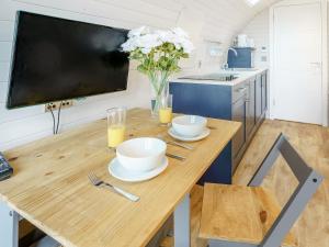 a kitchen with a wooden table with two bowls on it at Gwennol- Uk37573 in Llanboidy