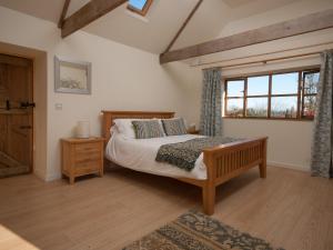 a bedroom with a large bed and a window at Tamar Orchard Barn in Gunnislake