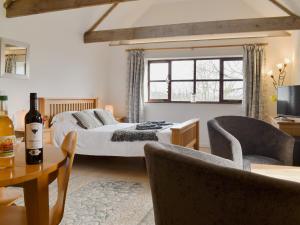 a bedroom with a bed and a table with chairs at Tamar Orchard Barn in Gunnislake