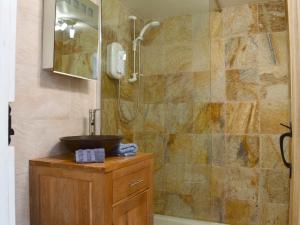 a bathroom with a shower and a sink and a tub at Tamar Orchard Barn in Gunnislake +6 photos