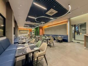 a dining room with tables and chairs and a chalkboard at Zip By Spree Hotels Chinchwad in Chinchwad