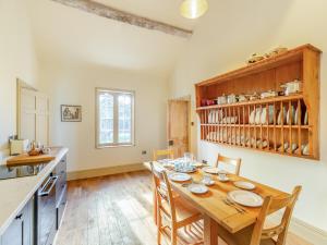 a kitchen and dining room with a wooden table and chairs at Apartment At Llanerchydol Hall in Welshpool