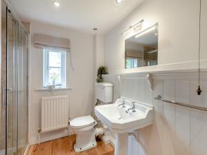 a white bathroom with a toilet and a sink at Swallow Cottages, No 1 - Uk46811 in Thurgarton +3 photos