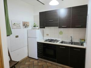 a kitchen with a sink and a white refrigerator at Villa Gioia Civita in Fabriano