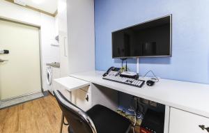 a desk with a computer and a monitor and a keyboard at Crystal Residence Hotel in Daejeon