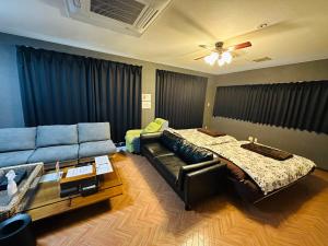 a living room with a couch and a bed at Hotel EL Utsunomiya 7 free parking in Utsunomiya