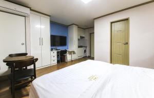 a bedroom with a bed and a desk and a television at Crystal Residence Hotel in Daejeon