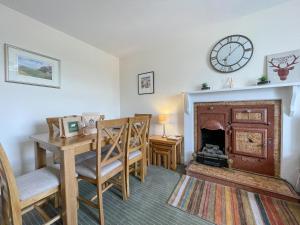 a room with a desk and a table and a fireplace at Pine Cottage - Dalcross in Dalcross