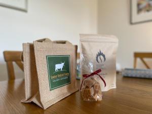 a table with two bags of food and a bag of bread at Pine Cottage - Dalcross in Dalcross +19 photos