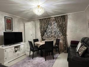 a living room with a table and chairs and a television at Casa Adi Sucevița in Voivodeasa