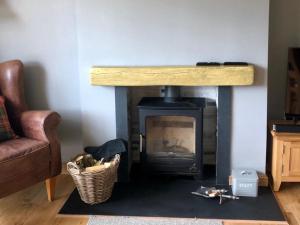 a living room with a fireplace and a couch at Clarinnes Cottage in Rowardennan