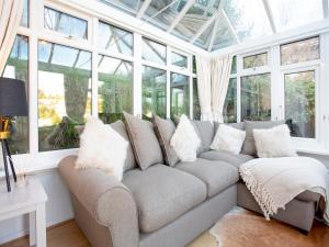 a living room with a couch and windows at Rock House Apartment in Torquay
