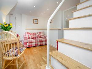 a living room with a staircase and a couch at Rock House Apartment in Torquay +9 photos