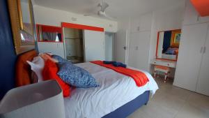 a bedroom with a bed with red and blue pillows at Nomads Nook 3 in Ramsgate +52 photos