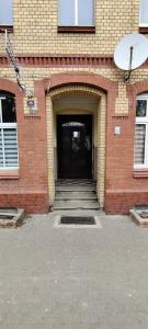 a brick building with a black door and a stairway at Mini Cozy Spot in Żagań
