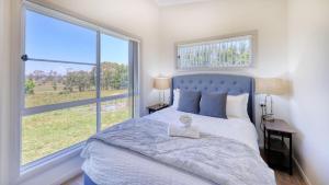 a bedroom with a bed and a large window at Red Hill Cabin#2 - 2-bedroom in Walcha