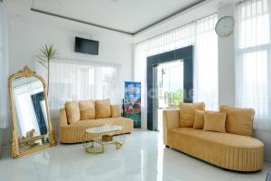 a living room with two couches and a mirror at Sazara Hotel Batu in Selecta