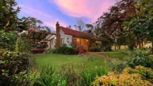 a house with a garden in front of it at Red Hill Cottage Walcha in Walcha