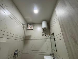 a bathroom with a sink and a light on the wall at GREEN WAY HOTEL & RESTAURANt in Gangānagar