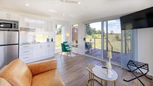a kitchen and living room with a couch and a table at Red Hill Cabin #1 Walcha in Walcha
