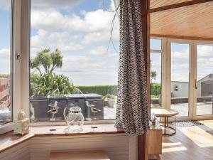 a room with a large window with a view of the ocean at Southcroft Lodge in Whiting Bay