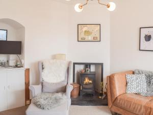 a living room with a chair and a fireplace at Southcroft Lodge in Whiting Bay