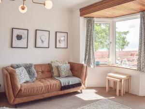 a living room with a couch and a window at Southcroft Lodge in Whiting Bay
