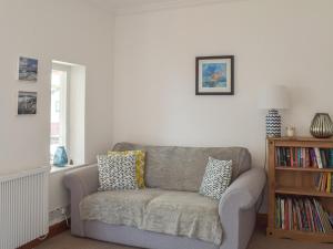 a living room with a couch and a book shelf at Southcroft Lodge in Whiting Bay +15 photos