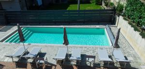 a swimming pool with four chairs and a group at B&B Mary in Alba