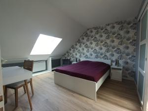 a bedroom with a bed and a table and a window at Les caves Sainte Anne Ecommoy 72220 in Écommoy