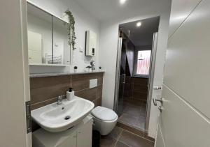a white bathroom with a sink and a toilet at CityLoft Wlan Zentral in Essen