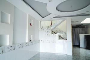 a white room with a staircase and white floors at Tâm An Hotel 2 in Nhơn Trạch
