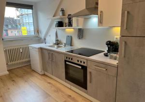 a kitchen with a sink and a stove top oven at CityLoft Wlan Zentral in Essen +5 photos