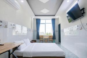 a bedroom with a bed and a table and a tv at Tâm An Hotel 2 in Nhơn Trạch