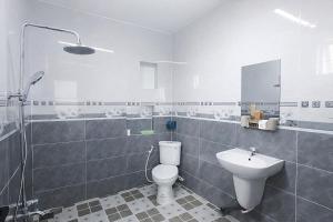 a white bathroom with a toilet and a sink at Tâm An Hotel 2 in Nhơn Trạch +16 photos