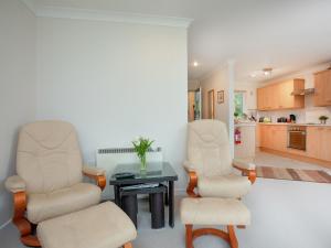 a living room with two chairs and a table at Gull Cottage in Falmouth