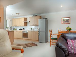a kitchen and dining room with a refrigerator and a table at Gull Cottage in Falmouth