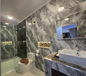 a bathroom with a sink and a toilet and a mirror at Beach Home Lanta in Ko Lanta +62 photos