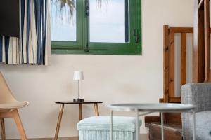 a living room with a table and a green window at Gouvia bay Serenity in Gouvia