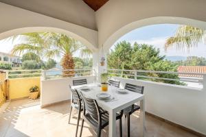 a dining room with a table and chairs on a balcony at Gouvia bay Serenity in Gouvia