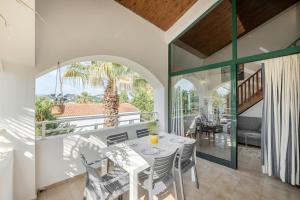 a dining room with a table and chairs on a balcony at Gouvia bay Serenity in Gouvia