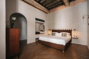 a bedroom with a large white bed and a dresser at Casa G. Firenze in Florence