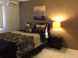 um quarto com uma cama e um candeeiro sobre uma mesa em Beautiful 2 bedroom 1 bath em Tamuning