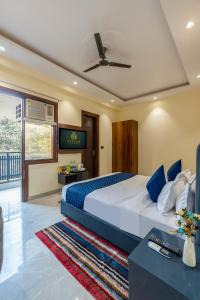 a bedroom with a large bed with a ceiling fan at Hotel Elite Clark in Noida +68 photos