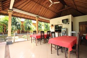 a dining room with a red table and chairs at Jepun Bali Bungalow in Nusa Lembongan