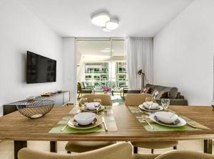 a living room with a wooden table with chairs at Redsearent suite with pool view in Eilat