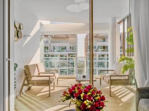 a living room with chairs and a vase of flowers at Redsearent suite with pool view in Eilat