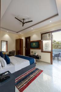 a bedroom with a king sized bed and a balcony at Hotel Elite Clark in Noida